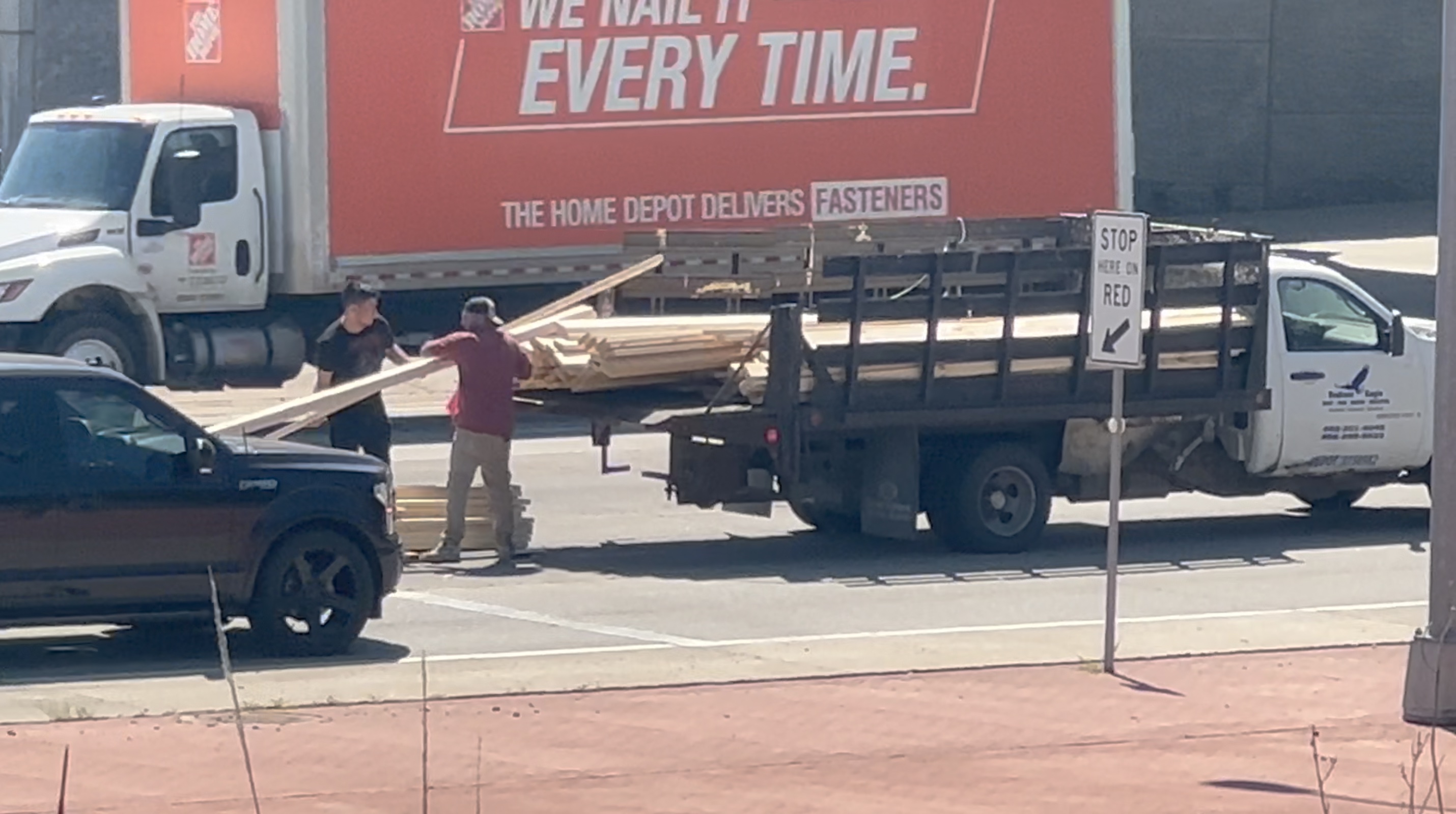 Men reload lumber in Highway 75 traffic